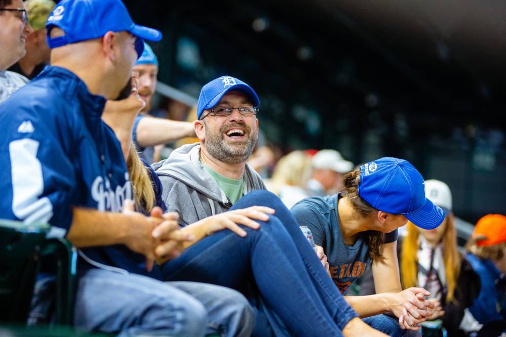 Photo of man laughing in the stands of Comerica Park